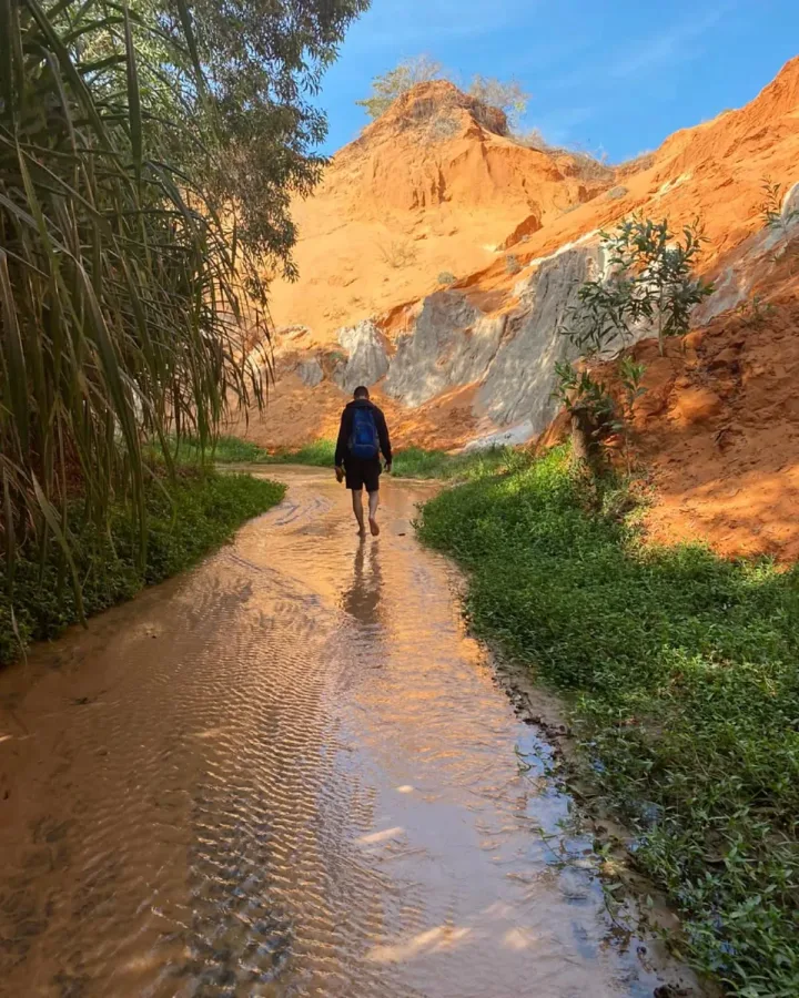 Marche dans le Fairy Stream entre sable orange et végétation